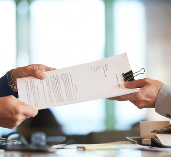 Business person giving partnership agreement to coworker